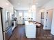 Bright kitchen with stainless appliances, white cabinetry, island with seating, and hardwood floors at 403 Old Town Village Rd, Waxhaw, NC 28173