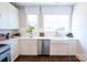 Bright kitchen features white cabinetry, stainless steel appliances, subway tile backsplash, and a farmhouse sink at 403 Old Town Village Rd, Waxhaw, NC 28173