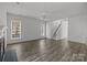 Living room with fireplace, two windows, wood floors, and staircase at 4627 Eaves Ln, Charlotte, NC 28215