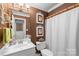 Cozy bathroom with white vanity, framed palm tree prints, and a shower with a curtain at 5001 Sharon Rd # H, Charlotte, NC 28210