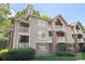 Condo building showcasing large windows, multiple private balconies, and lush green landscaping at 5001 Sharon Rd # H, Charlotte, NC 28210