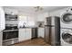 Well-lit kitchen with stainless steel appliances and white cabinetry featuring a stacked washer and dryer at 517 Roberts Ave, York, SC 29745