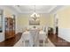 Formal dining room with elegant chandelier, wainscoting, and large windows, perfect for entertaining guests at 518 May Green Dr, Clover, SC 29710