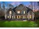 Charming two-story stone home with a lush green lawn and well-manicured landscaping provides great curb appeal at 518 May Green Dr, Clover, SC 29710