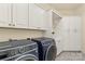 Well-organized laundry room features modern washer and dryer, plus custom white cabinetry at 518 May Green Dr, Clover, SC 29710