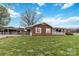 Single-story home with brick exterior, an American flag, and well-kept lawn at 5643 Twinkle Dr, Concord, NC 28025