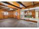 Living room showcasing wood paneling, beams and an open layout to kitchen and dining area at 5643 Twinkle Dr, Concord, NC 28025