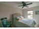 Bright bedroom with comfortable bed, a decorative rocking chair and a window that provides natural light at 6021 Sweetbay Ln, Indian Land, SC 29707