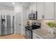 A modern kitchen featuring granite counters, white cabinets, and stainless steel appliances at 6021 Sweetbay Ln, Indian Land, SC 29707