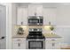 Well-lit kitchen features stainless steel appliances, granite countertops, and stylish white cabinets at 6021 Sweetbay Ln, Indian Land, SC 29707