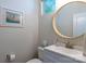 Stylish powder room with a round mirror, vanity, and modern fixtures at 6021 Sweetbay Ln, Indian Land, SC 29707