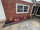Close-up of a colorful flower bed with red brick border beneath windows at 603 E Main St, Rock Hill, SC 29730
