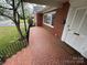 Vintage front porch with patterned brick floor and a white front door at 603 E Main St, Rock Hill, SC 29730