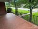 Covered front porch with brick flooring, decorative iron railings, and neighborhood views at 603 E Main St, Rock Hill, SC 29730