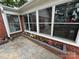 Bright sunroom with many windows, red brick border, and colorful flower beds at 603 E Main St, Rock Hill, SC 29730