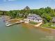 Waterfront home with lush trees, boat dock with boat on the calm waters at 8150 Malibu Pointe Ln, Denver, NC 28037