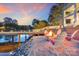 Relax by the lake on this property with a waterfront fire pit and inviting Adirondack chairs at 8150 Malibu Pointe Ln, Denver, NC 28037