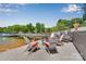 Lakeside seating area with fire pit and dock access, creating a relaxing outdoor space near the water at 8150 Malibu Pointe Ln, Denver, NC 28037
