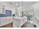 Bright, eat-in kitchen with white cabinets, large center island, and beautiful patterned backsplash at 8150 Malibu Pointe Ln, Denver, NC 28037