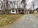 Charming single-story brick home with a well-maintained front yard and a gravel driveway at 837 Corwin Dr, Charlotte, NC 28213