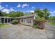 Charming home exterior with mature landscaping, flowering bushes, and a fenced yard at 8509 Anette Ave, Mint Hill, NC 28227