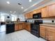 Charming kitchen with wooden cabinets, black appliances, and stylish granite countertops at 864 Ledgestone Ct, Fort Mill, SC 29708