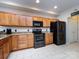 Well-lit kitchen features granite countertops, wooden cabinetry and modern black appliances at 864 Ledgestone Ct, Fort Mill, SC 29708