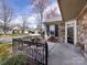 Inviting front porch featuring a stone facade, black shutters, wrought iron railing and outdoor seating at 864 Ledgestone Ct, Fort Mill, SC 29708