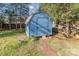 Blue backyard shed provides extra storage, nestled among the trees at 9624 Buckskin Ln, Mint Hill, NC 28227