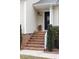 Close up of welcoming front entrance with brick steps, trimmed bushes, and black front door at 9624 Buckskin Ln, Mint Hill, NC 28227