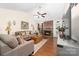 Cozy living room with a brick fireplace, vaulted ceiling, wood floors, and lots of natural light at 9624 Buckskin Ln, Mint Hill, NC 28227