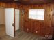 Bedroom with wood paneling, neutral carpet, and a closet with storage at 1138 Choyce Ave, Charlotte, NC 28217