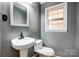 Cozy bathroom with a pedestal sink, toilet, and natural light from the window at 1142 Canterbury Dr, Lancaster, SC 29720