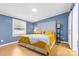 Sunlit bedroom showcases blue accent walls, a decorative headboard, and a comfy bed at 117 Pine Bluff Dr, Mooresville, NC 28117
