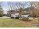 Landscape view of house, features a two-car garage, a quaint front porch, and yard at 117 Pine Bluff Dr, Mooresville, NC 28117