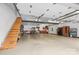Spacious garage with staircase, work area, overhead lighting and garage door at 117 Pine Bluff Dr, Mooresville, NC 28117