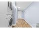 Well-lit laundry room features a stacked washer and dryer and durable laminate flooring at 117 Pine Bluff Dr, Mooresville, NC 28117