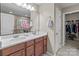 Bathroom features a double vanity with stone countertops, a large mirror, and a walk-in closet at 12302 Volusia Ct, Charlotte, NC 28262
