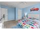 Bright, blue bedroom featuring a ceiling fan, light carpet and a colorful, car-themed bedspread at 12302 Volusia Ct, Charlotte, NC 28262
