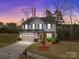 Charming two-story home with blue siding, stone accents, and a well-manicured front yard at dusk at 12302 Volusia Ct, Charlotte, NC 28262