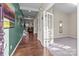Inviting foyer featuring hardwood floors, a view of the stairs and living room, and a carpeted office at 12302 Volusia Ct, Charlotte, NC 28262