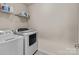 Functional laundry room with washer, dryer, and overhead shelving for storage at 12302 Volusia Ct, Charlotte, NC 28262