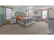 Spacious main bedroom with a tufted headboard, sitting area, and neutral color palette with orange accents at 12302 Volusia Ct, Charlotte, NC 28262