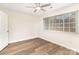 Bright bedroom with laminate floors, a ceiling fan, and a large window overlooking the exterior at 1310 Green Oaks Ln # H, Charlotte, NC 28205