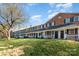 Exterior view of townhomes featuring brick facade, shutters, porches and expansive lawn at 1310 Green Oaks Ln # H, Charlotte, NC 28205