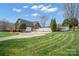 Beautiful brick home featuring a well-manicured lawn, a white fence, and mature trees at 1529 Indian Springs Nw Dr, Conover, NC 28613