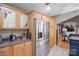 Kitchen area with stainless steel refrigerator, wood cabinets, granite countertops, and backsplash at 1529 Indian Springs Nw Dr, Conover, NC 28613