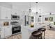 Modern kitchen boasts stainless steel appliances, white cabinetry, and a sleek breakfast bar at 1611 Carlton Ave, Kannapolis, NC 28083