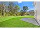 A backyard featuring green grass, surrounding trees, and concrete pad at 1615 Carlton Ave, Kannapolis, NC 28083