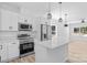 Bright kitchen features white cabinets, stainless steel appliances, and an island with breakfast bar at 1615 Carlton Ave, Kannapolis, NC 28083